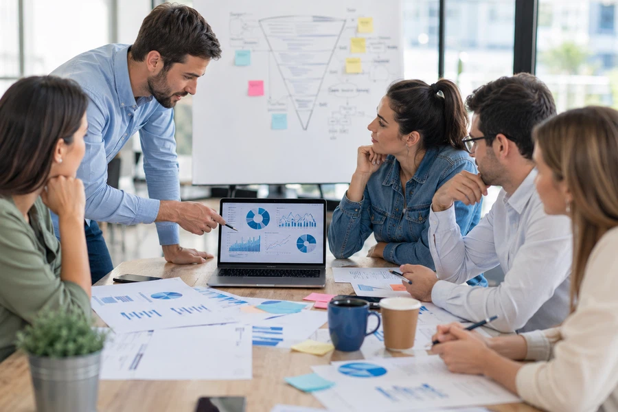 Equipo de marketing analizando un embudo de ventas con gráficas de analítica en una oficina